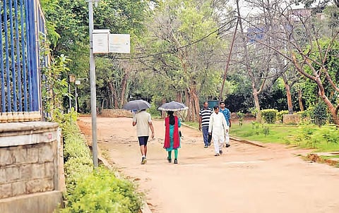 Walkers take a stroll at a walkway in KBR park, in Hyderabad on Wednesday