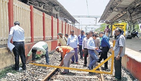 A railway team verifying the distance between the track and fence | Express