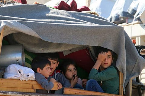 Syrian children ride a truck carrying their personal belongings at a Lebanese army checkpoint in Wadi Hmeid in the Bekaa valley, after leaving the village of Arsal to return to their homes in Syria's Qalamoun region on July 23, 2018. (Photo | AFP)