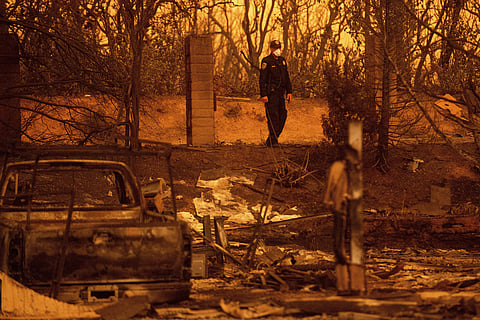 California Highway Patrol officer Gavin Graham surveys homes leveled by the Carr Fire in the Lake Keswick Estates area of Redding, Calif. (Photo | AP)