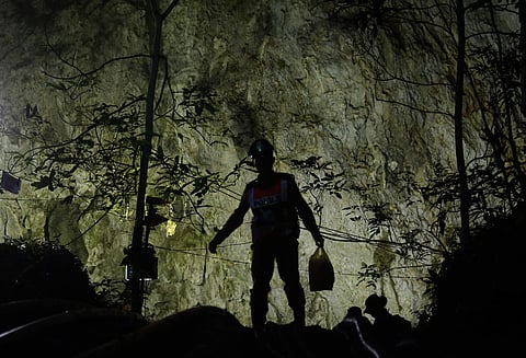 Rescuers make their way down at the entrance to a cave complex where 12 boys and their soccer coach went missing, in Mae Sai, Chiang Rai province, in northern Thailand, Sunday, July 1, 2018. The frantic effort to locate them in the cave for a week picked