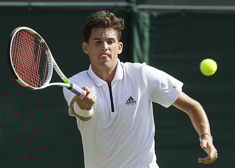 Dominic Thiem plays a return shot to Marcos Baghdatis during their men's singles match on the second day at the Wimbledon Tennis Championships in London. | AP