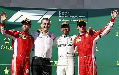 Second placed Ferrari driver Sebastian Vettel of Germany, Mercedes race engineer Riccardo Musconi, race winner Mercedes driver Lewis Hamilton of Britain and Ferrari driver Kimi Raikkonen of Finland, from left to right, at the podium of Hungarian Grand Pri
