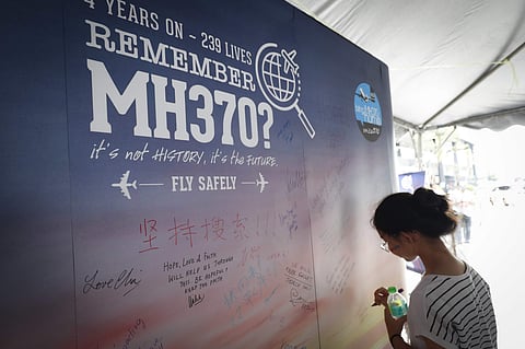 A girl writes a condolence message during the Day of Remembrance for MH370 event in Kuala Lumpur. (Photo | AP)
