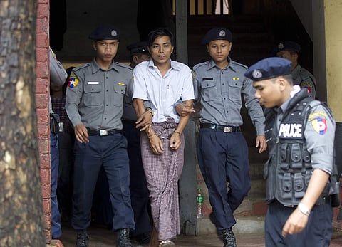 Reuters journalist Kyaw Soe Oo, center, is escorted by polices as they leave the court after their trial Monday. (Photo | AP)