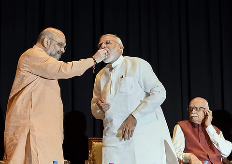 New Delhi Prime Minister Narendra Modi being offered sweets by BJP President Amit Shah as senior leader LK Advani looks on during BJP Parliamentary Party meeting in New Delhi on Tuesday July 31 2018.