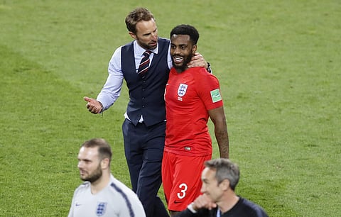 England head coach Gareth Southgate, center left, leaves the field with England's Danny Rose after defeating Colombia in a penalty shootout at the end of the round of 16 match between Colombia and England at the 2018 soccer World Cup in the Spartak Stadiu