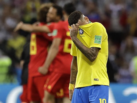 Brazil's Neymar reacts as Belgium players celebrate after Brazil is knocked out by Belgium following their quarterfinal match at the 2018 soccer World Cup in the Kazan Arena, in Kazan, Russia, Friday, July 6, 2018. | AP