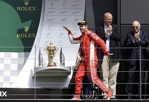 Ferrari driver Sebastian Vettel of Germany celebrates on the podium after winning the British Formula One Grand Prix at the Silverstone racetrack, Silverstone, England. (AP)