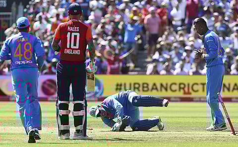 India's MS Dhoni tumbles as he catches England captain Eoin Morgan out, during the third T20 match between England and India, at the Brightside Ground, in Bristol, England, Sunday July 8, 2018. | AP
