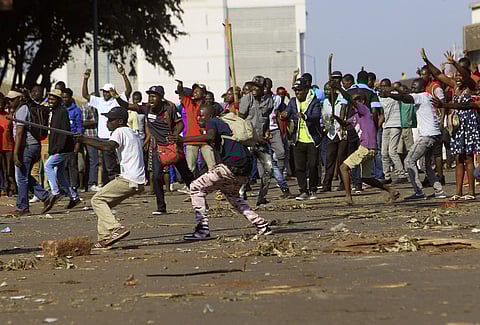 Opposition party supporters react after police fired tear gas, in Harare. (Photo | AP)