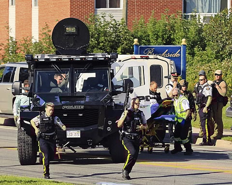 Police and RCMP officers survey the area of a shooting in Fredericton, New Brunswick, Canada. (Photo | AP)