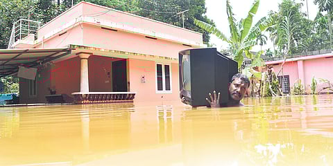 Sunil, a resident of Kuttikattukara in Eloor, which is lying submerged in the overflowing Periyar, moves out with a TV set to a safer location as water level continued to rise on Friday submerging nearly 100 houses. Many families have been shifted to reli