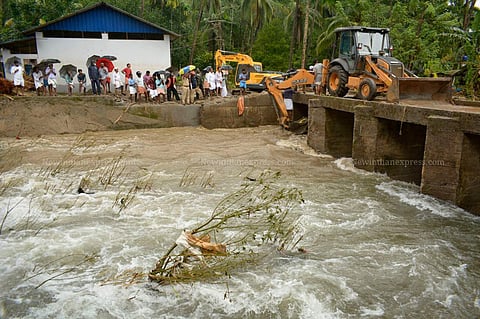 People who came to see the flood affected areas standing dangerously closed to the collapsing side wall of the water stream at Kannappankundu in Kozhikode. (Photo | Manu R Mavelil/EPS)