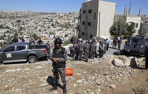 Jordanian forces secure the area Sunday, Aug. 12, 2018, after the side of a building collapsed when assailants opened fire and set off explosions late Saturday that killed four members of the security forces trying to storm the suspected militant hideout