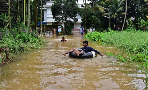 A boy lounging around in a tube in the flood water outside his house on the banks of Periyar river near Pathalam. | (Albin Mathew | EPS)