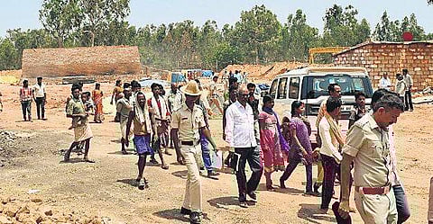 Police leading bonded labourers out of the kiln in Bagalur