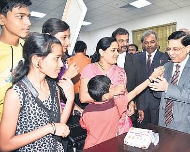 Four children of the reunited couple offer sweets to CJI Justice Dipak Misra after he held a Special Lok Adalat at the new court complex in Hubballi on Sunday | Express