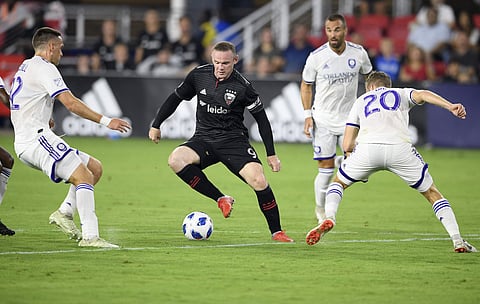 DC United forward Wayne Rooney (9) dribbles the ball against Orlando City midfielder Oriol Rosell (20) and defender Shane O'Neill, left, during the first half of an MLS match. (Photo | AP)