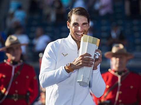 Rafael Nadal, of Spain, bites on the championship trophy after defeating Stefanos Tsitsipas, of Greece, during men's finals Rogers Cup tennis tournament action in Toronto. (Photo | AP)