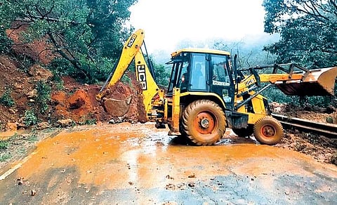 An earthmover clearing mounds of soil on Mangaluru-Madikeri highway near Madenadu on Monday I Express