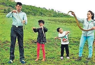 Anand Chitti along with Nirzara and their two children handling snakes in Belagavi | Express