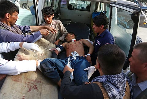 A man who was injured in a deadly suicide bombing that targeted a training class in a private building in the Shiite neighborhood of Dasht-i Barcha is placed in an ambulance in western Kabul, Afghanistan, Wednesday. ( Photo | AP)