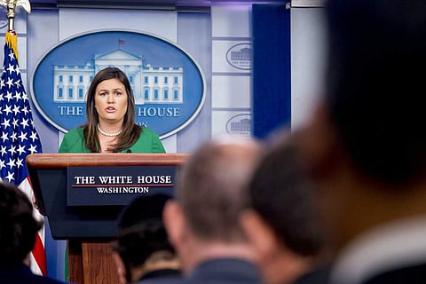 White House press secretary Sarah Huckabee Sanders reads a statement from President Donald Trump announcing that he will remove the security clearance from former CIA Director John Brennan during the daily press briefing at the White House, Wednesday, Aug
