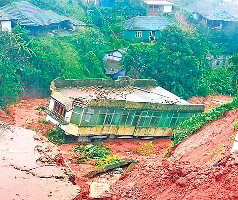 A two-storey house situated on a hill-top near Muttappa Temple in Madikeri slid down along with the mud during a landslide on Thursday. No one was inside the building at the time of the incident | EXPRESS