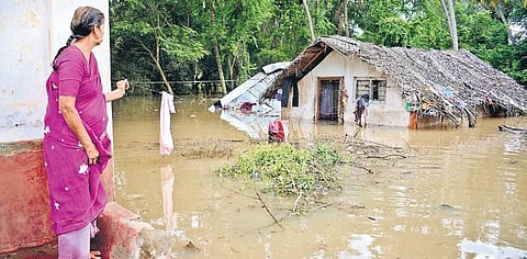 A woman looks at a house submerged in Nanjungud on Saturday | Shriram B N