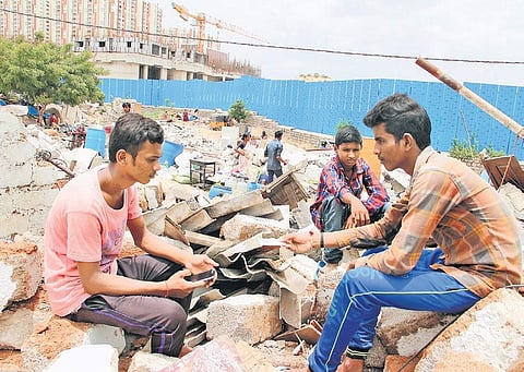 Residents of Gachibaowli’s Keshavnagar sit amid the rubble of what were once their homes on Tuesday. As many as 200 structures were removed. | (S Senbagapandiyan | EPS)