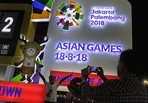 In this Aug. 18, 2017, file photo, a man has his photo taken at the one-year countdown clock to the 2018 Asian Games in Jakarta, Indonesia. | AP