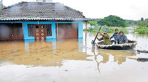 Two men being moved to safer ground by a coracle on Graveyard Road in Koppa of Kodagu district (Photo | Udayashankar S / EPS)