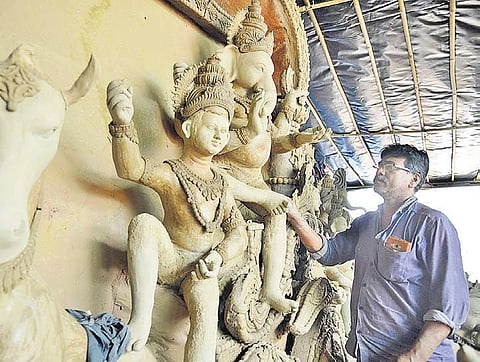 An idol-maker gives finishing touches to his work ahead of Ganesh Chaturthi, in Bengaluru on Sunday. Some immigrant workers from Bengal have set up a makeshift tent near Airport Road where these idols are made | Pushkar V