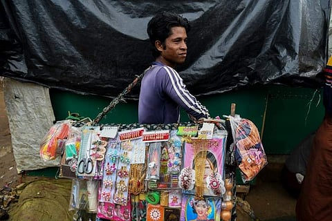 A Rohingya refugee carries various items to sell in the Kutupalong camp in Cox's Bazar. (Photo | AFP)