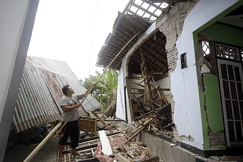 A man tries fixing his 'house' in Lombok. (Photo | AP)