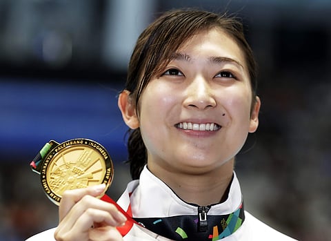 Japan's Rikako Ikee holds up her gold medal after winning the women's 50m freestyle final during the swimming competition at the 18th Asian Games in Jakarta. (Photo | AP)