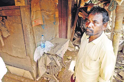 Subramanium from Tamil Nadu in front of a damaged house at Pathalam in Kochi on Friday; (right) a boy sleeping on a plastic sack after the furniture at his house got washed away in the flood | Melton Antony