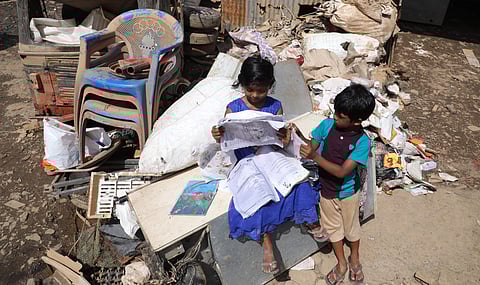 Sabia and her brother who returned home from relief camp check their school text books which were found wet and unusable at Pathalam in Kochi on Friday. (Photo | EPS/Melton Antony)