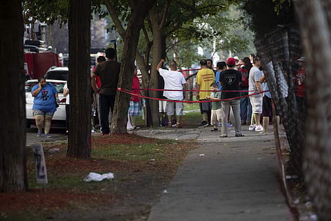 People stand around at the scene after a fire killed several people including multiple children. (Photo | AP)