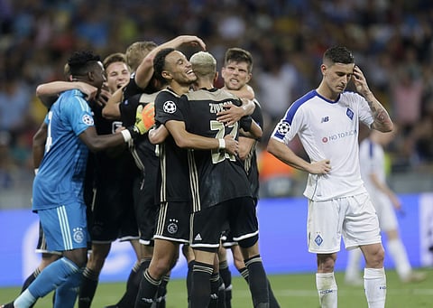 Dynamo Kiev's Benjamin Verbic (R) reacts as Ajax's players celebrate the victory after their Champions League, play-off round, second leg | AP