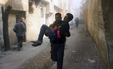 Syrian Civil Defense group carrying a young man who was wounded during airstrikes and shelling by Syrian government forces in Ghouta. (File | AP)