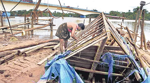 P V Joy, the owner of a Chinese fishing net, removing what is left behind of the net which was completely damaged in the flood at Varapuzha on Wednesday | A Sanesh
