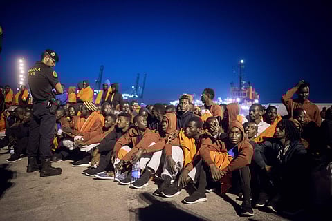 In this Tuesday, July 31, 2018 photo, a group of migrants sit in front of Spanish Police officers at the port of Algeciras, southern Spain, after being rescued by Spain's Maritime Rescue Service in the Strait of Gibraltar. (Photo | AP)