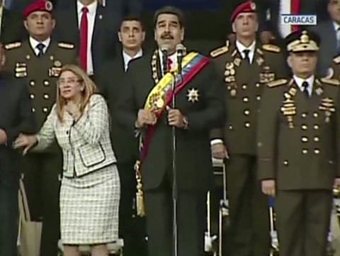 In this still from a video provided by Venezolana de Television, Presiden Nicolas Maduro, center, delivers his speech as his wife Cilia Flores winces and looks up after being startled by and explosion, in Caracas, Venezuela, August 4, 2018. (Photo | AP)