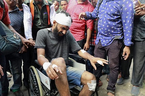 Associated Press (AP) photographer A. M. Ahad leaves a hospital after he was beaten by ruling party activists during a student demonstration for the deaths of two college students in a road accident. (Photo | AFP)
