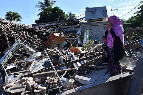 A woman stands on the ruins of her home in Lombok Islands where a 6.9 magnitude earthquake destroyed 80 percent homes. (Photo | AFP)