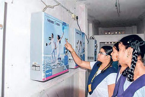 Students using the napkin vending machine at a school (File | EPS)