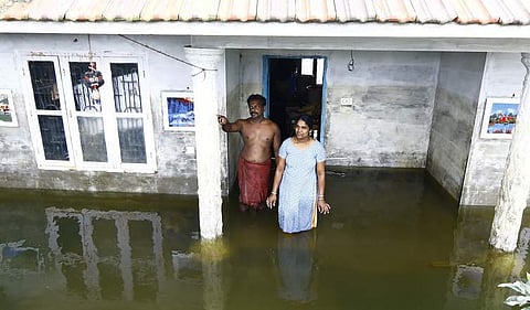 Anilkumar and Radhika of Paruthuvalavu standing inside their inundated house. The house under construction was almost submerged in floodwaters. (Photo | Arun Angela/EPS)