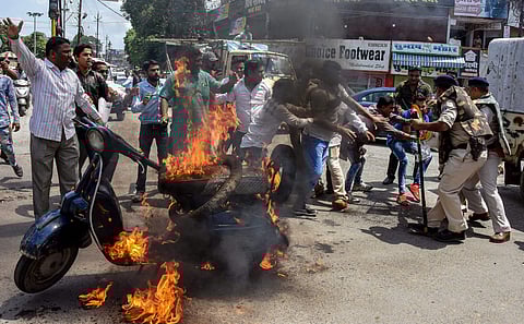 Congress party workers set a scooter on fire during 'Bharat Bandh' protest called by Congress and other parties against fuel price hike in Jabalpur, Monday. (Photo | PTI)